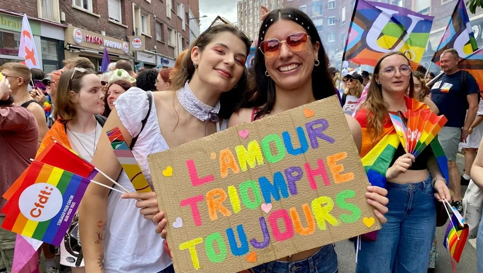 Deux manifestantes avec une pancarte 'L'amour triomphe toujours' lors de la Pride à Amiens en 2025